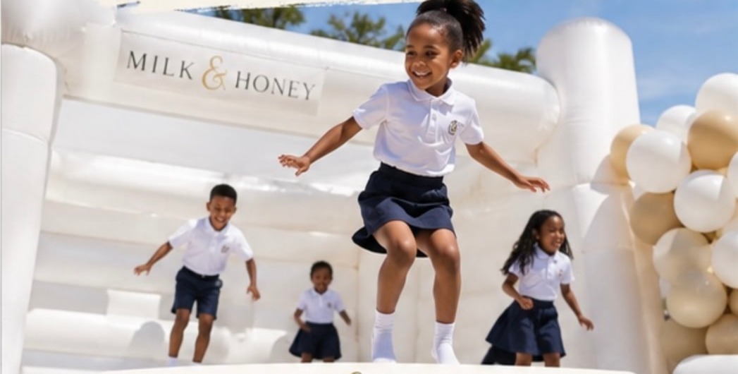 Learners in school uniform jumping on a white inflatable castle